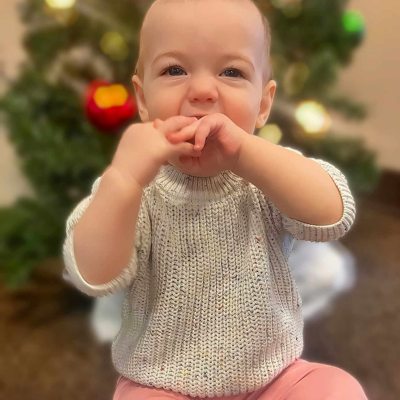 Emma is registered to the contest to win money with this photo: baby, babylaughing, biting, bodypart, clothing, eating, face, finger, food, hand, happy, head, knitwear, pants, person, photography, portrait, sitting, sleeve, smile