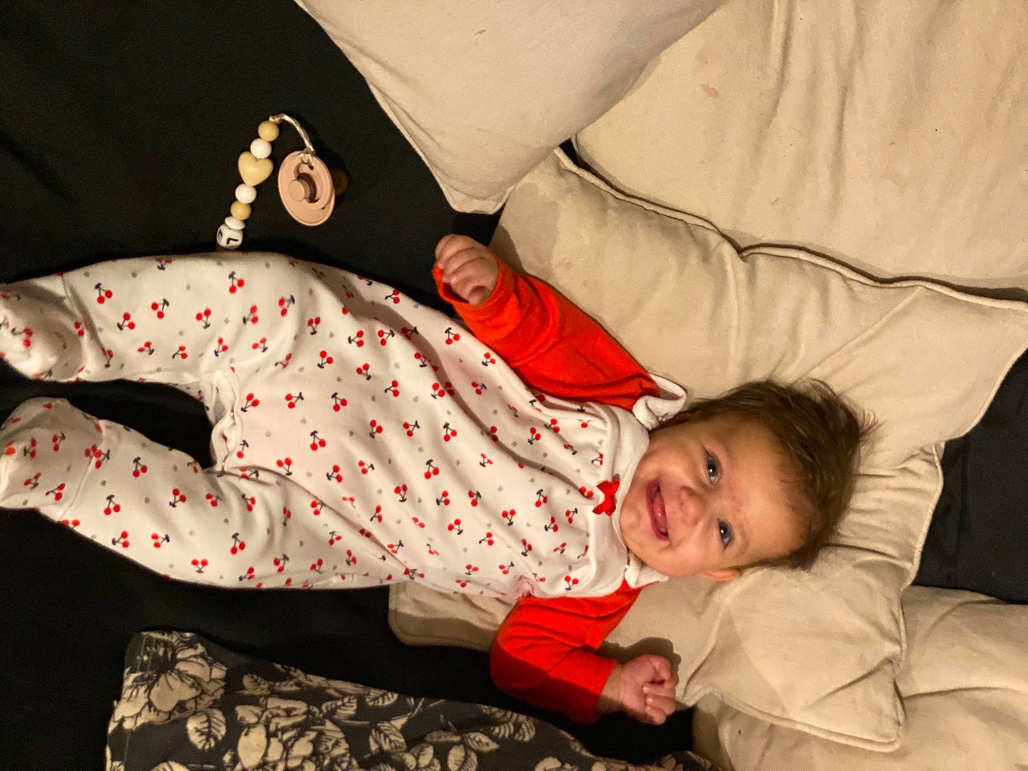Lara a rejoint le concours — aidez-le/la à gagner de superbes lots ! baby, baby_toddler_clothing, child, comfort, face, gesture, happy, joy, lap, linens, mammal, orange, pattern, person, red, room, sitting, sleeve, smile, textile