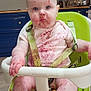 baby, high_chair, kitchen, messy, berry_stains, face, arms, legs, straps, clothing, expression, child, indoor, floor, cabinet, countertop, appliance, skin, foot, hand