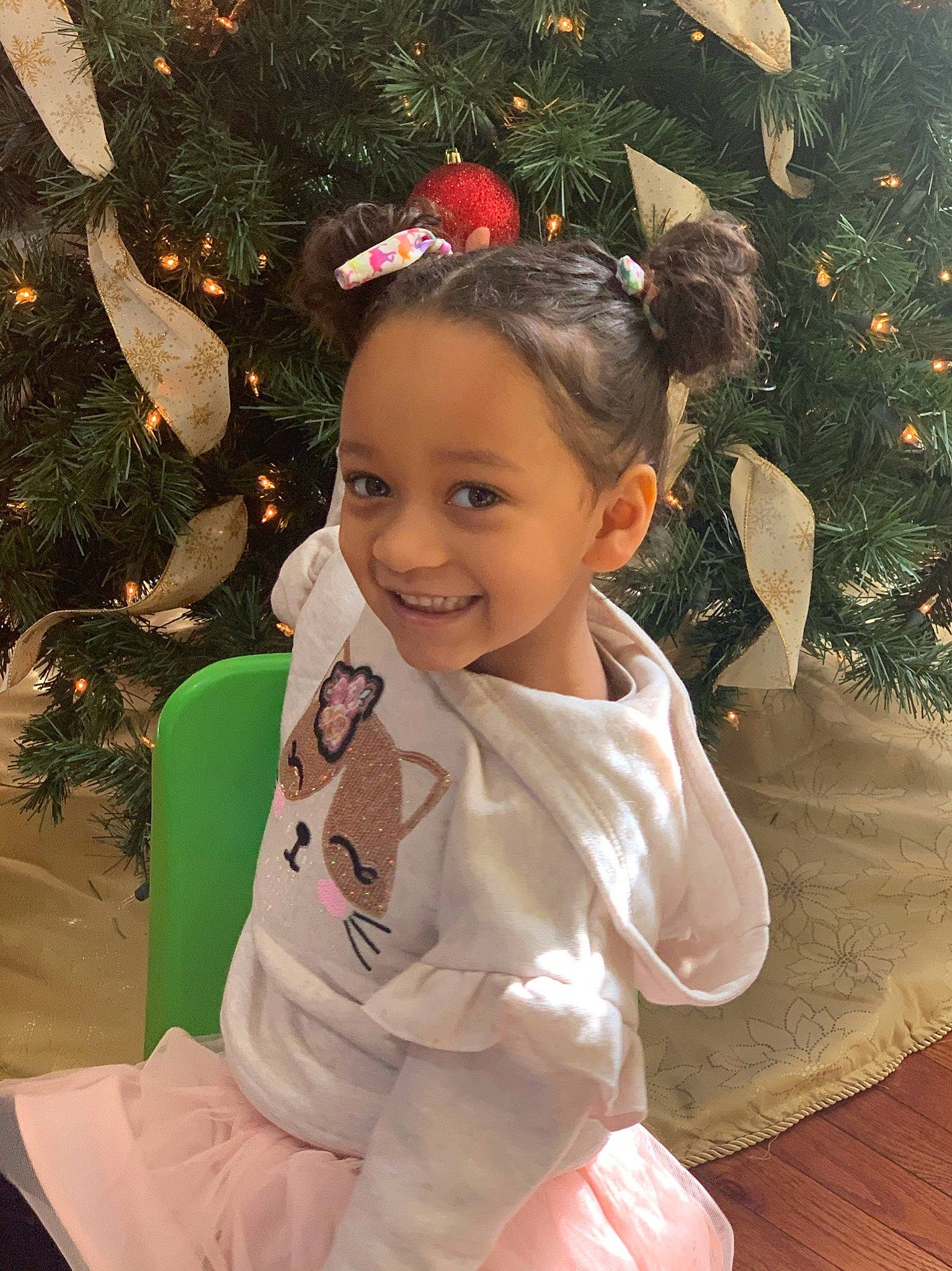 Ava Marie is registered to the contest to win money with this photo: baby_toddler_clothing, child, christmas_decoration, christmas_ornament, christmas_tree, event, facial_expression, fun, hair, hairstyle, happy, head, holiday_ornament, human_body, joy, ornament, person, plant, smile, standing