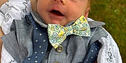 Gabriel is registered to the contest to win money with this photo: baby, infant, bow_tie, suspenders, shirt, blanket, hand, face, outdoor, grass, person, portrait, cute, newborn, clothing, fashion, closeup, smile, skin, expression