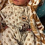 newborn, baby, sleeping, pajamas, blanket, soft, cozy, footwear, puppy_slippers, giraffe_pattern, infant, cute, child, face, peaceful, wrapped, indoors, clothing, resting, portrait