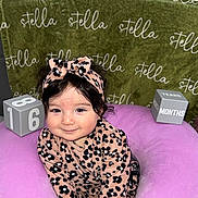 Stella is registered to the contest to win money with this photo: baby, child, smiling, leopard_print, headband, purple_cushion, green_blanket, stella, blocks, age, months, cute, portrait, indoors, soft_toys, happy, person, infant, clothing, sitting
