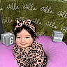 baby, child, smiling, leopard_print, headband, purple_cushion, green_blanket, stella, blocks, age, months, cute, portrait, indoors, soft_toys, happy, person, infant, clothing, sitting