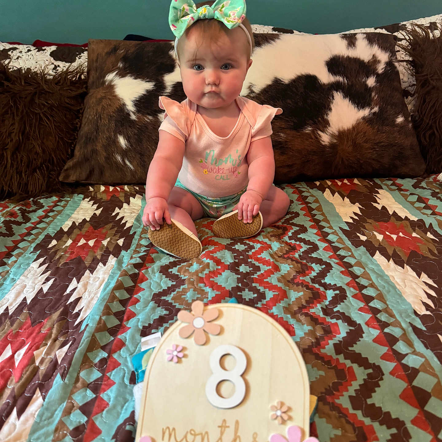 Danilin joined the competition — help win amazing prizes! baby, bed, bow, child, chubby_cheeks, cowhide, curious, cute, flower, headband, indoors, infant, months, onesie, pattern, pillow, portrait, quilt, sitting, wooden_sign