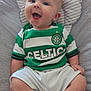 baby, child, smiling, celtic_football_club, green_and_white, striped_shirt, socks, sitting, cushion, happy, infant, portrait, cute, indoor, clothing, shorts, seat, head, face, person