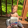 Bryson joined the competition — help win amazing prizes! barefoot, child, daylight, greenery, happy, hostess_donettes, messy_face, nature, outdoor, pants, porch, shirtless, sitting, smiling, snack, sunlight, toddler, trees, wooden_floor, wooden_railings