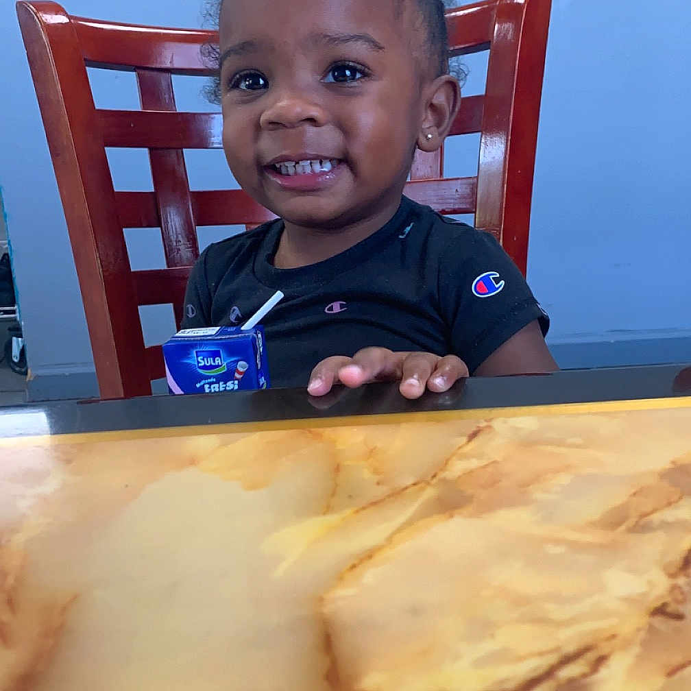 Emoura is registered to the contest to win money with this photo: architecture, baby, bodypart, building, cream, diningroom, diningtable, face, finger, furniture, hand, head, indoors, person, photography, plywood, portrait, room, table, wood