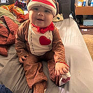 Paxton is registered to the contest to win money with this photo: baby, bed, casual, child, clothing, costume, cute, fabric, face, footwear, hand, happy, home, indoor, person, plush, red_bow, smiling, sock_monkey, toy