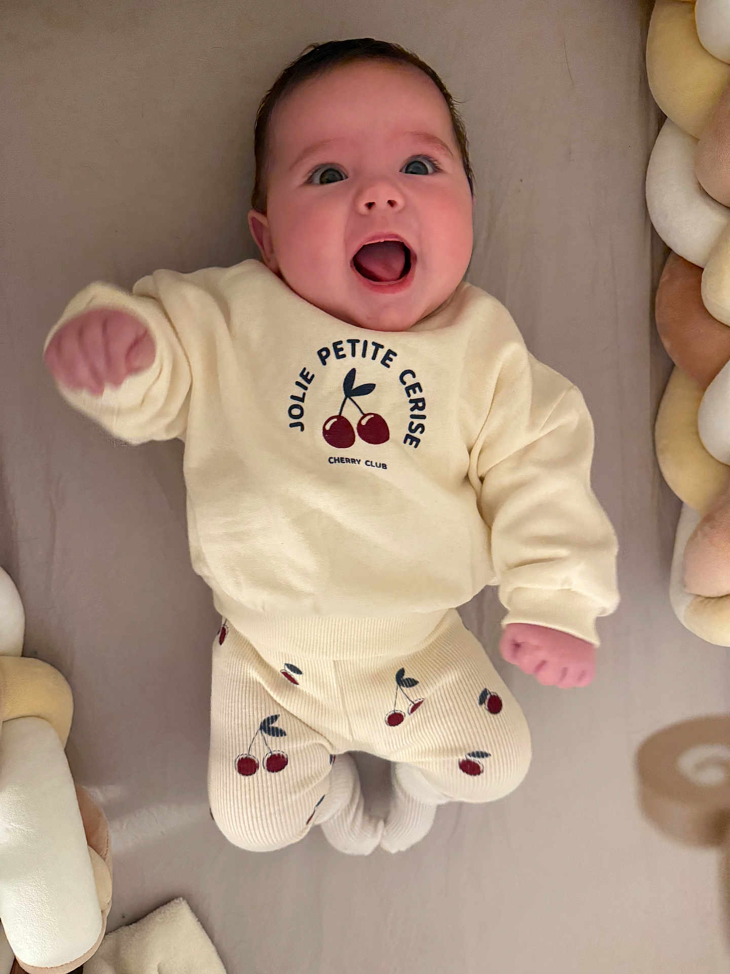 Sianna a rejoint le concours — aidez-le/la à gagner de superbes lots ! baby, infant, child, smiling, happy, face, expression, clothing, sweater, pants, cherry_pattern, socks, plush, braided_cushion, soft_toys, indoor, portrait, cute, lying_down, neutral_background