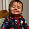 baby, celebration, child, clothing, cute, expression, face, festive, fireworks_pattern, happy, high_chair, hot_dog, ice_cream, indoor, onesie, person, portrait, smiling, toddler, wooden_chair