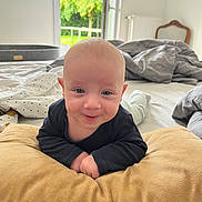 Oscar a rejoint le concours — aidez-le/la à gagner de superbes lots ! baby, infant, pillow, bed, blanket, smile, face, indoors, window, greenery, clothing, person, head, happy, furniture, room, light, skin, young_child, expression