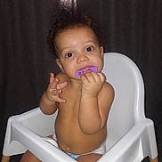 Chandler joined the competition — help win amazing prizes! baby, child, infant, high_chair, teether, purple_teether, sitting, indoors, portrait, face, eyes, curly_hair, bare_chested, diaper, hands, smiling, curious, window, curtains, furniture