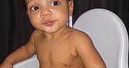 Chandler joined the competition — help win amazing prizes! baby, child, infant, high_chair, portrait, sitting, indoors, curly_hair, brown_skin, bare_chested, diaper, face, eyes, looking_at_camera, serious_expression, white_chair, curtains, window, flash_photography, home