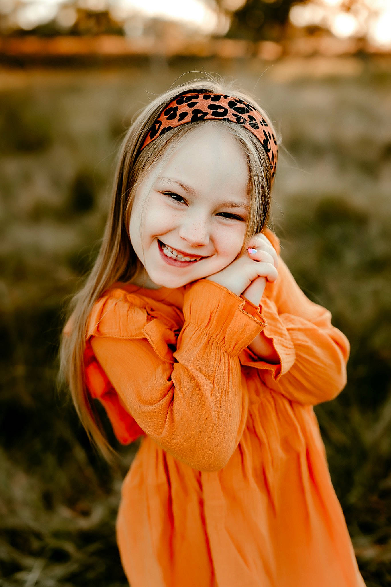 Everleigh is registered to the contest to win money with this photo: blond, child, dress, flash_photography, gesture, grass, grassland, happy, headband, headwear, human_body, jewellery, joy, long_hair, orange, outerwear, people_in_nature, person, plant, smile