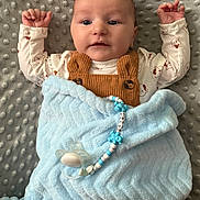 Jacob joined the competition — help win amazing prizes! baby, blanket, pacifier, pacifier_clip, blue_blanket, brown_overalls, baby_clothing, infant, face, arms, lying_down, textured_blanket, comfort, child, cute, indoors, sleep_time, soft_texture, portrait, newborn