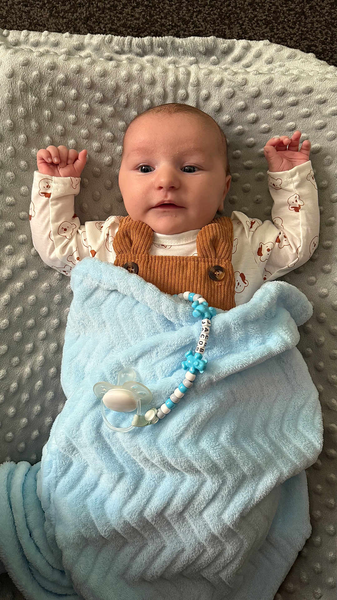 Jacob joined the competition — help win amazing prizes! baby, blanket, pacifier, pacifier_clip, blue_blanket, brown_overalls, baby_clothing, infant, face, arms, lying_down, textured_blanket, comfort, child, cute, indoors, sleep_time, soft_texture, portrait, newborn
