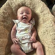 Kayliana joined the competition — help win amazing prizes! baby, infant, smiling, onesie, cartoon_print, blanket, beige, happy, cute, child, sitting, chubby, cozy, indoor, face, human, skin, limbs, apparel, soft