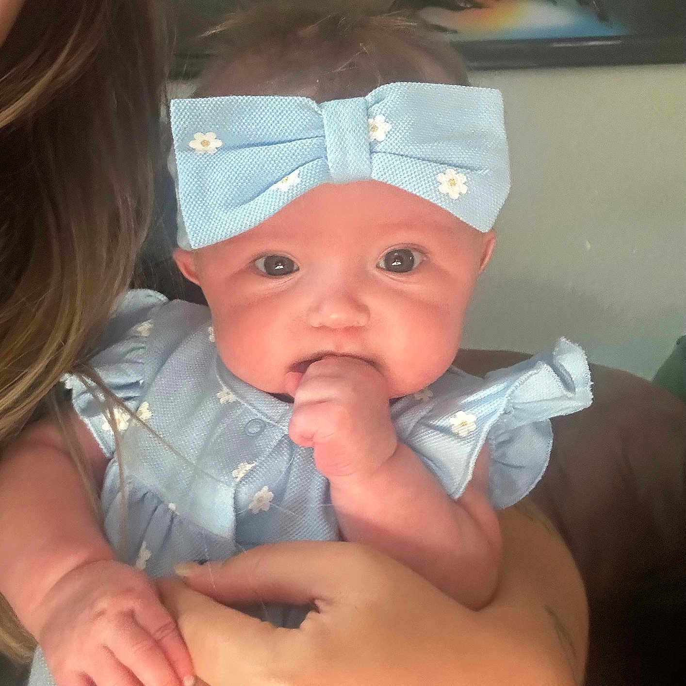 Kayliana joined the competition — help win amazing prizes! adult_hand, baby, blue, child, clothing, cute, dress, face, fist, hair, hand, headband, holding, home, indoor, infant, person, portrait, skin, wall_art