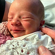 Emilee joined the competition — help win amazing prizes! newborn, baby, sleeping, smiling, face, hand, blanket, knitted, cozy, soft_light, closeup, infant, peaceful, skin, portrait, cute, child, resting, tender, love