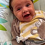 Isma a rejoint le concours — aidez-le/la à gagner de superbes lots ! baby, smiling, infant, bib, clothing, seat, pattern, animal_design, happy, face, eyes, hand, expression, cute, cozy, hair, indoor, child, portrait, colorful