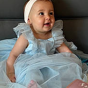 Cataleya participe au concours pour gagner de l'argent avec cette photo : baby, child, dress, headband, pink_flower, blue_dress, sitting, bed, happy, curious, portrait, indoors, cute, infant, smiling, person, soft_tulle, clothing, fabric, light