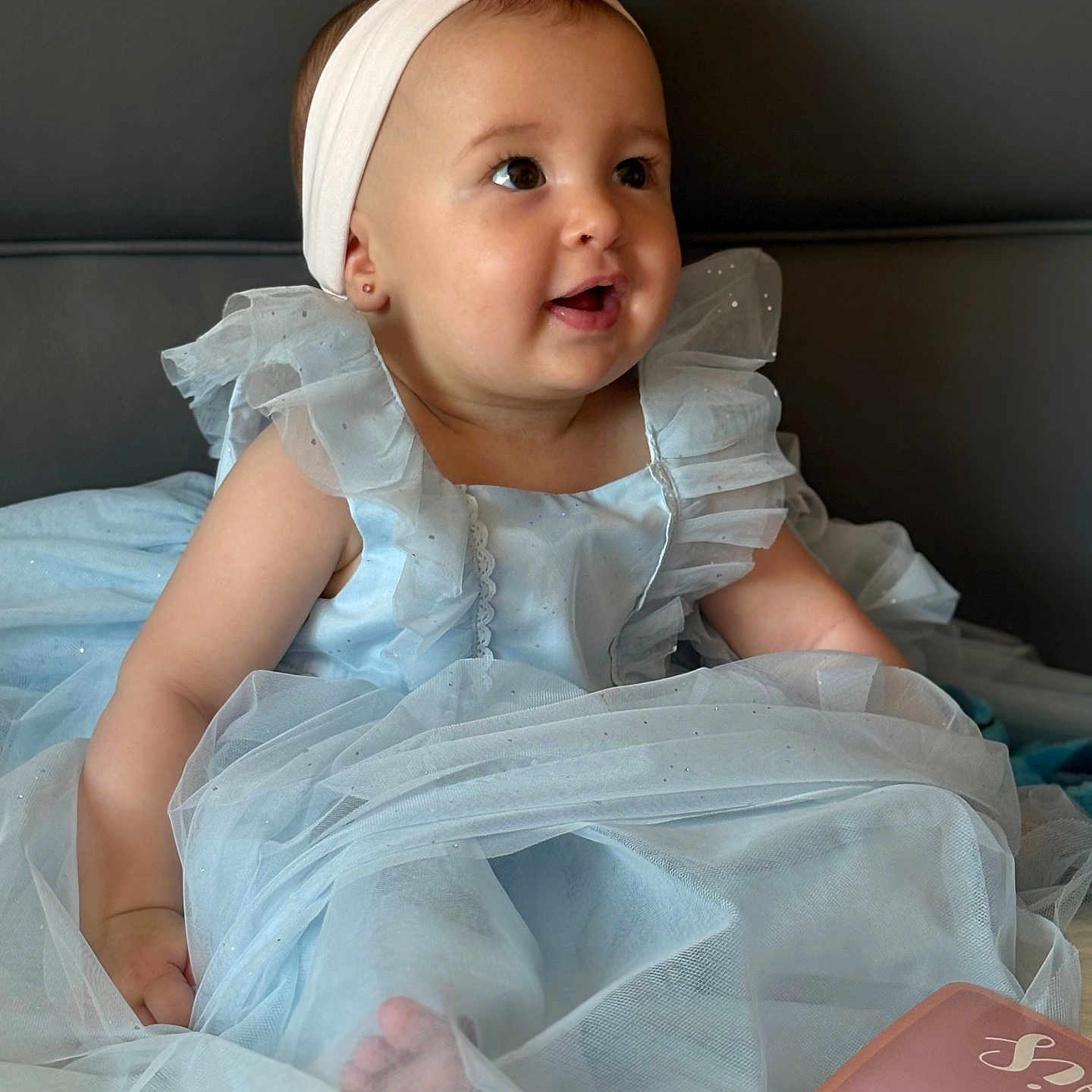 Cataleya participe au concours pour gagner de l'argent avec cette photo : baby, child, dress, headband, pink_flower, blue_dress, sitting, bed, happy, curious, portrait, indoors, cute, infant, smiling, person, soft_tulle, clothing, fabric, light