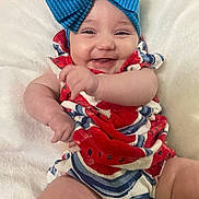 Blakelee is registered to the contest to win money with this photo: baby, smiling, blue_bow, red_clothing, white_blanket, happy, infant, child, cute, portrait, close_up, chubby_arms, candid, indoors, soft_texture, colorful_outfit, cheerful, person, headwear, playful