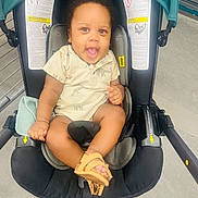 Jayceon is registered to the contest to win money with this photo: accessories, baby, babylaughing, car, clothing, face, footwear, happy, head, pants, person, photography, portrait, shoe, sitting, smile, stroller, t_shirt, transportation, vehicle