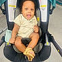 accessories, baby, babylaughing, car, clothing, face, footwear, happy, head, pants, person, photography, portrait, shoe, sitting, smile, stroller, t_shirt, transportation, vehicle