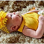 baby, infant, pacifier, headband, flower_headband, yellow_clothing, floral_blanket, textured_blanket, side_profile, ear, arm, hand, cheek, soft_light, portrait, newborn, cute, cozy, indoor, studio_photo