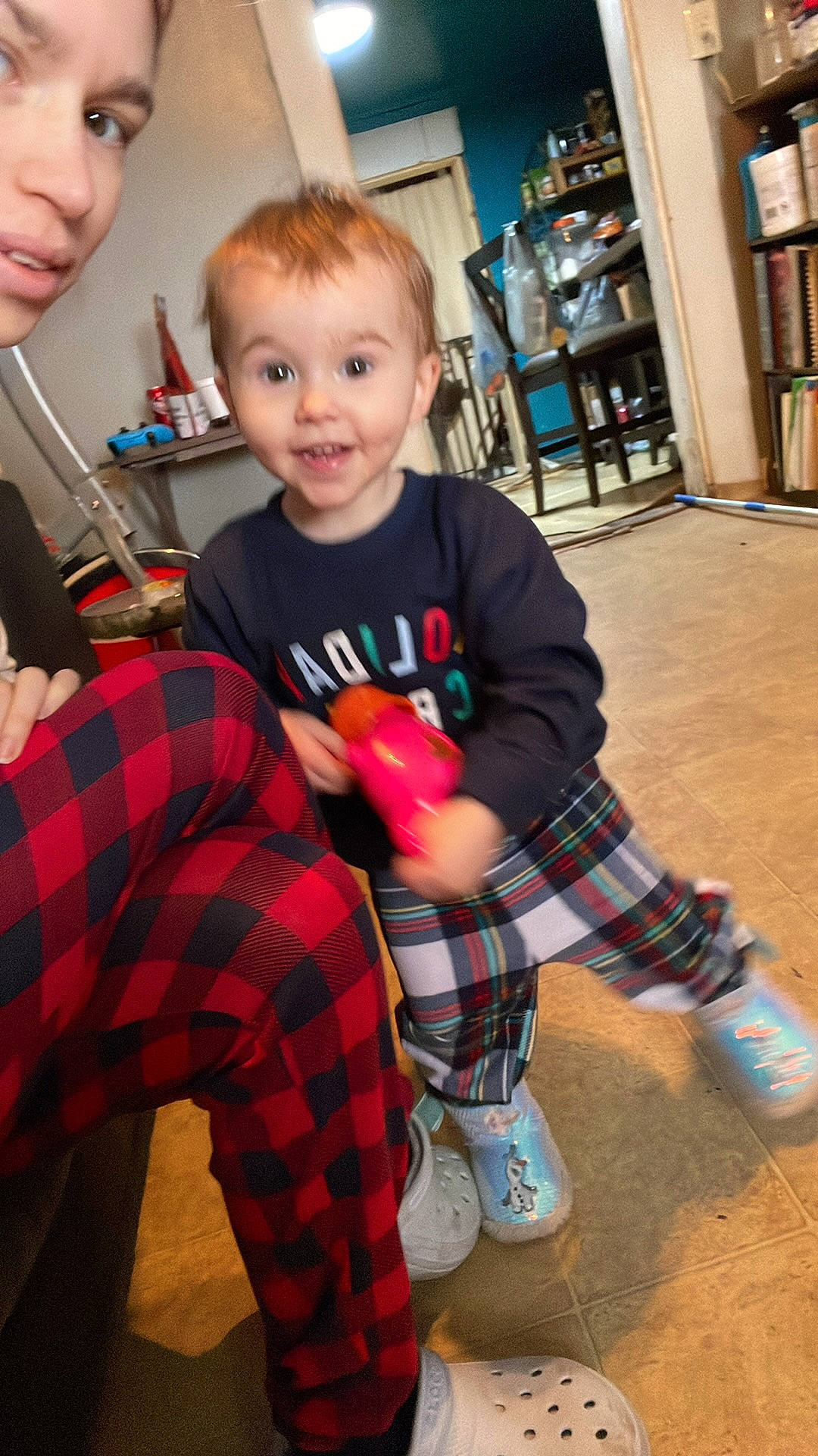Emma-lee is registered to the contest to win money with this photo: child, christmas, christmas_eve, event, fun, happy, holiday, pattern, person, plaid, sitting, sleeve, smile, sock, standing, t_shirt, tartan, thigh, toddler, toy