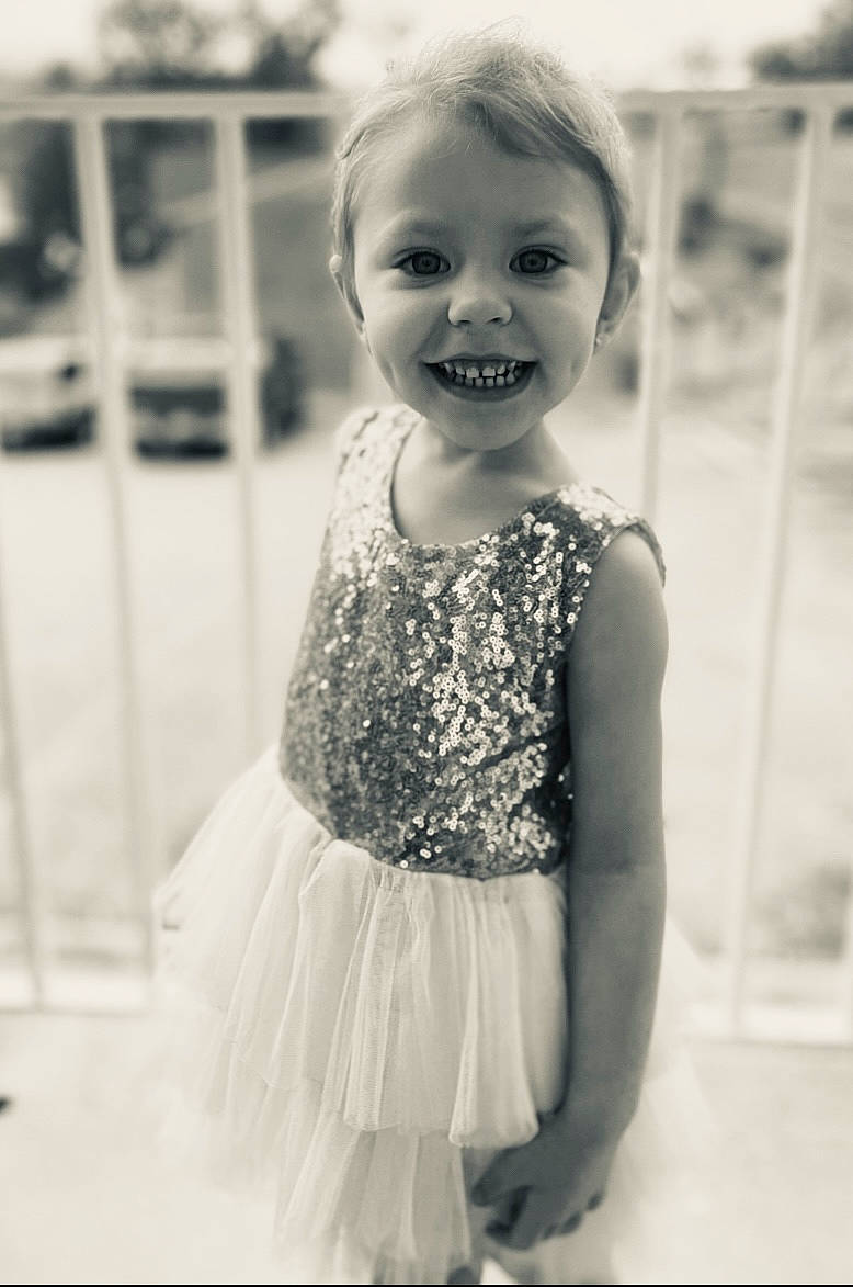 Carmen is registered to the contest to win money with this photo: black_and_white, child, day_dress, dress, face, fashion_design, flash_photography, fun, happy, iris, joy, monochrome, monochrome_photography, person, shoulder, skin, smile, standing, style, toddler