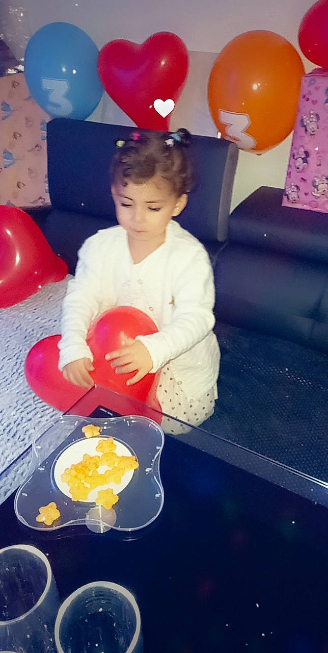 Sanna participe au concours pour gagner de l'argent avec cette photo : balloon, child, design, event, flooring, fun, happy, leisure, lighting, organ, party_supply, person, photograph, pink, recreation, red, sitting, snapshot, space, toddler