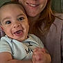 Roman is registered to the contest to win money with this photo: baby, woman, smile, happy, clapping, indoor, couch, clothing, person, face, head, red_hair, joy, family, child, portrait, closeup, expression, seated, casual