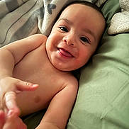 Roman joined the competition — help win amazing prizes! baby, smiling, child, face, hands, bed, blanket, sheet, skin, happy, infant, portrait, cute, lying_down, indoors, young, expression, person, closeup, playful