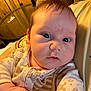 Benjamin joined the competition — help win amazing prizes! baby, infant, pajamas, face, expression, hand, cushion, person, indoor, wooden_wall, table, glass, soft_lighting, closeup, skin, hair, resting, curious, cozy, child