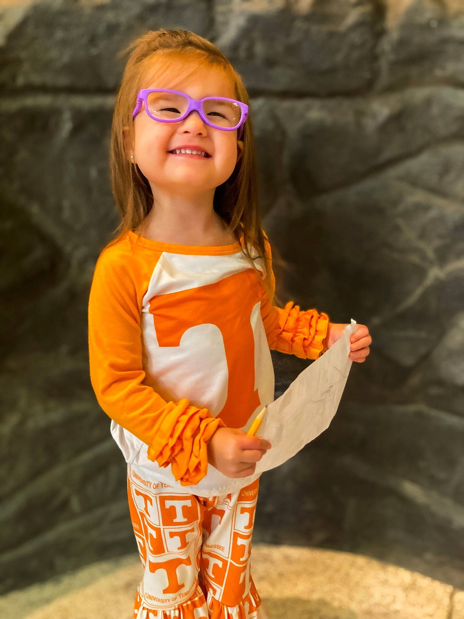 Makenzie is registered to the contest to win money with this photo: blond, eyewear, fashion_design, fawn, fun, glasses, hairstyle, happy, head, joy, neck, orange, peach, people_in_nature, person, sitting, sleeve, smile, toddler, trunk