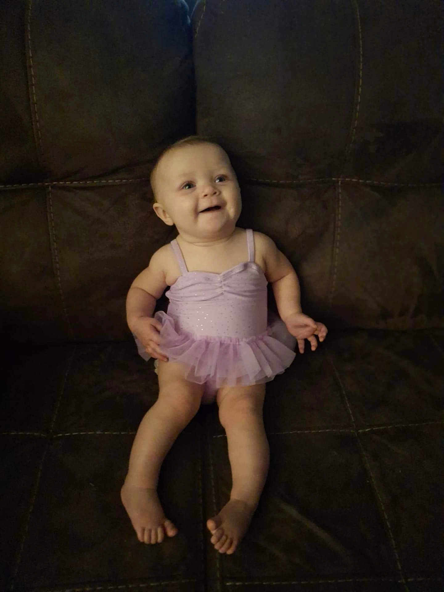 Addisyn joined the competition — help win amazing prizes! baby, tutu, dress, couch, smile, happy, infant, sitting, indoor, child, person, legs, feet, skin, face, clothing, furniture, cute, young, joyful