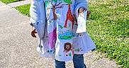 Mellodie-Grace joined the competition — help win amazing prizes! child, girl, smiling, dress, jungle_animals, sidewalk, sunny, grass, apartment_buildings, holding_paper, jacket, footwear, sandals, happy, outdoor, portrait, cute, playful, daytime, shadow