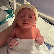 Mahé a rejoint le concours — aidez-le/la à gagner de superbes lots ! newborn, baby, infant, towel, hat, hand, skin, face, person, child, cute, indoors, soft_light, support, gentle, sleepy, wrapped, human, portrait, newborn_care