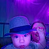 Maximus is registered to the contest to win money with this photo: baby, child, toddler, portrait, indoor, purple_lighting, string_lights, hat, fedora, smiling, playful, sibling, face, eyes, hand, shirt, closeup, home, photography, family