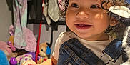 Rachell Mendoza joined the competition — help win amazing prizes! child, toddler, curly_hair, denim_overalls, smiling, plush_toy, zebra_toy, indoor, clothing, toys, happy, cute, baby, face, portrait, young_child, sitting, room, cozy