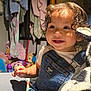 child, toddler, curly_hair, denim_overalls, smiling, plush_toy, zebra_toy, indoor, clothing, toys, happy, cute, baby, face, portrait, young_child, sitting, room, cozy