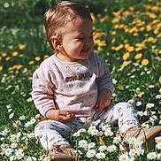 Lïa participe au concours pour gagner de l'argent avec cette photo : child, toddler, smiling, sitting, flowers, daisies, grass, outdoor, nature, sunlight, spring, greenery, happy, cute, baby_clothes, field, blossoms, playful, daylight, casual