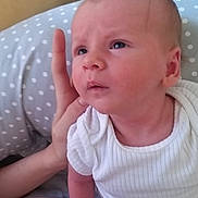 ézio a rejoint le concours — aidez-le/la à gagner de superbes lots ! baby, infant, child, onesie, hand, face, expression, polka_dot, cushion, fabric, skin, person, sitting, indoors, floor_tile, support, curious, soft, white_clothing, purple_cloth