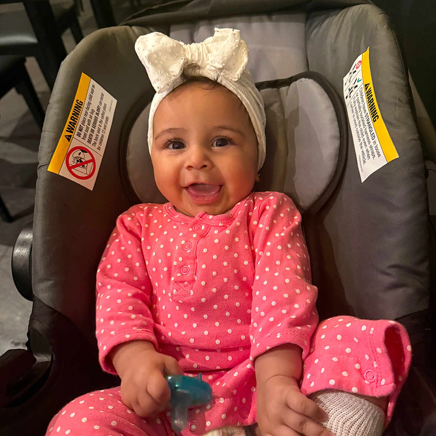 Illiana is registered to the contest to win money with this photo: baby, child, infant, car_seat, pink_clothing, polka_dot, headband, bow, pacifier, smiling, happy, cute, indoors, seat, diaper, sock, portrait, person, comfort, baby_toys
