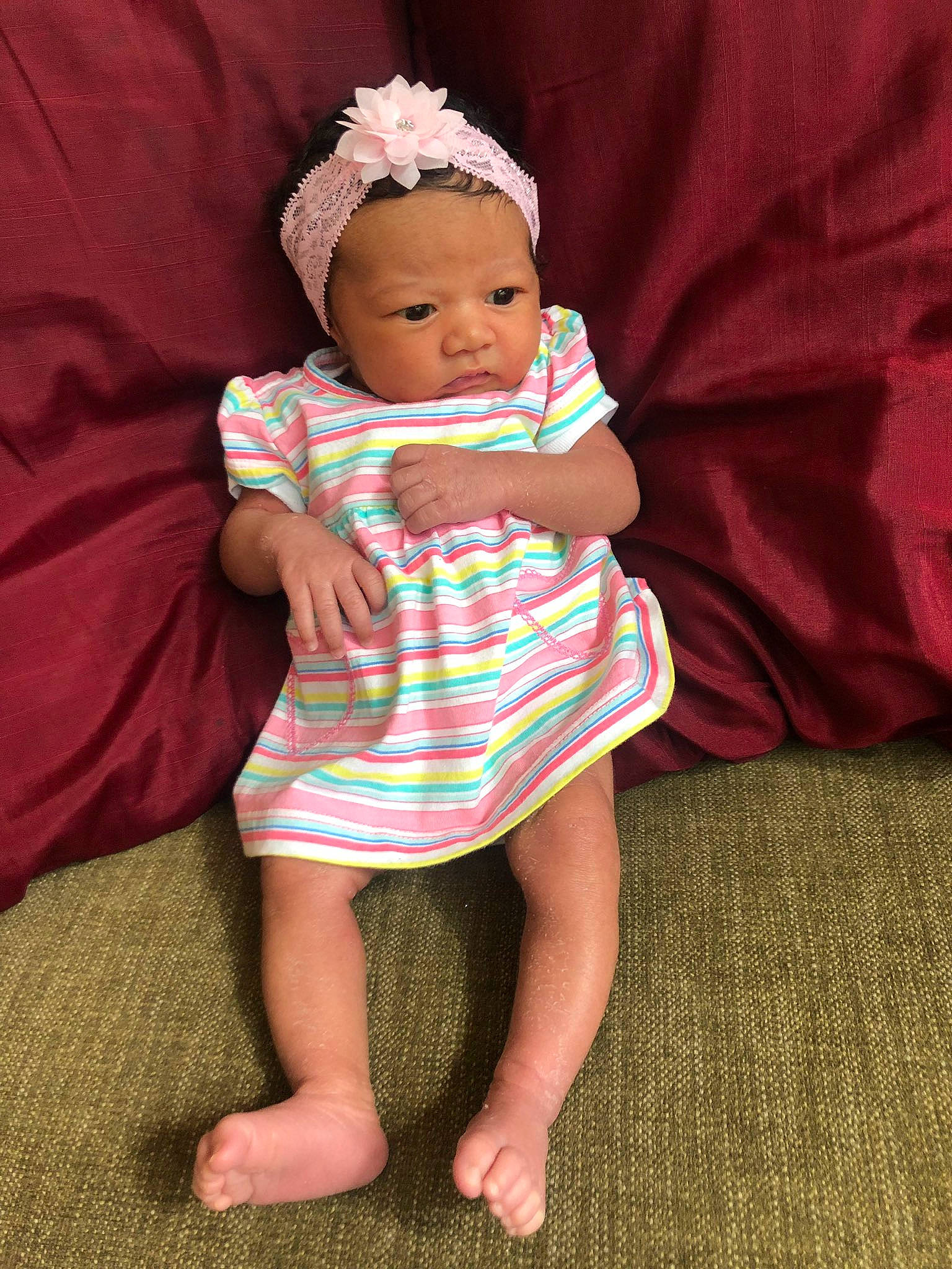 London Rose is registered to the contest to win money with this photo: baby, baby_products, baby_toddler_clothing, cheek, child, dress, hair_accessory, headgear, pattern, person, pink, product, sitting, skin, textile, toddler