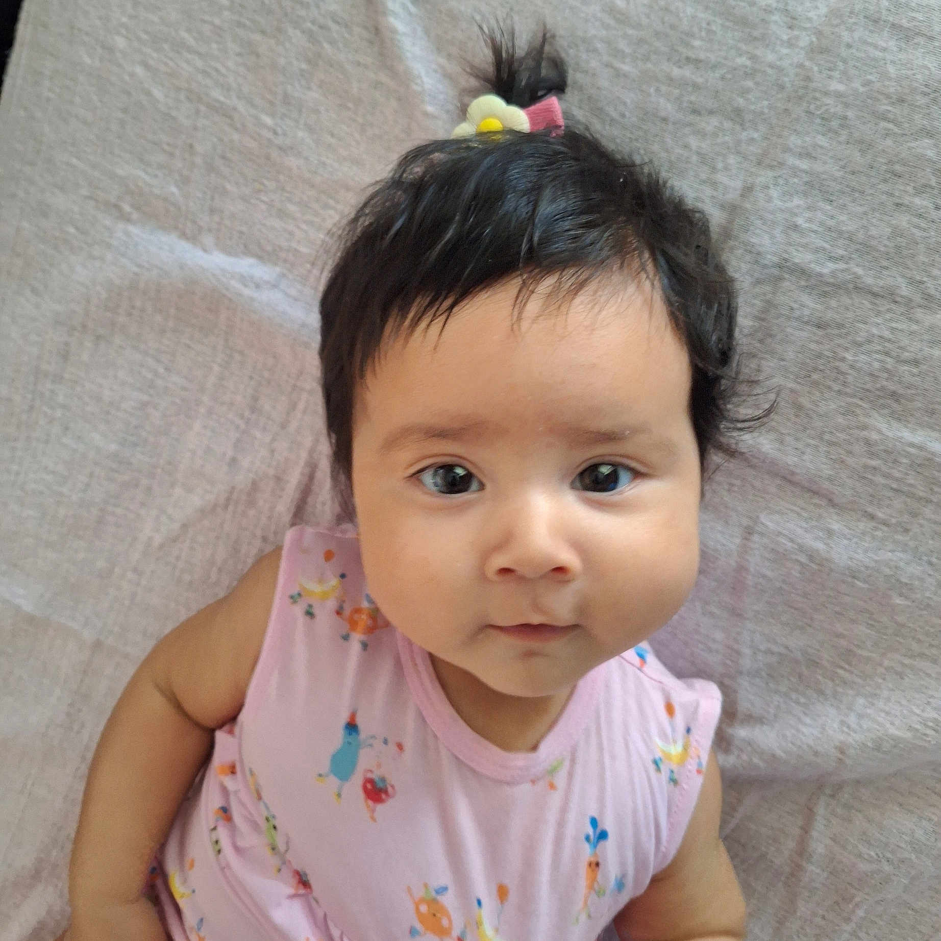 Candace joined the competition — help win amazing prizes! baby, blanket, cheeks, child, cute, expression, face, flower_clip, hair, indoors, infant, looking_at_camera, lying_down, pink_clothing, ponytail, portrait, skin, sleeveless, soft_texture, young_child