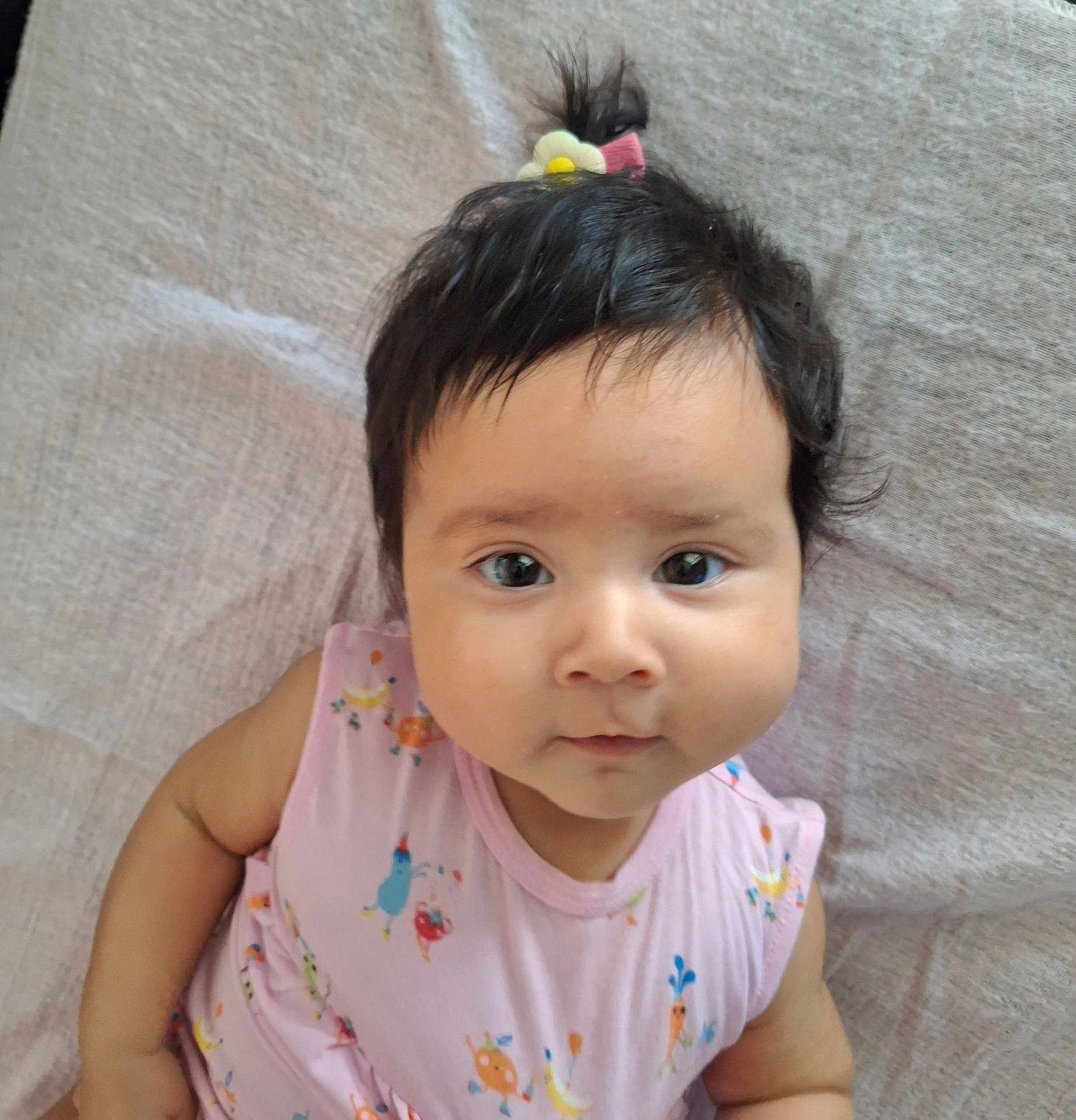 Candace joined the competition — help win amazing prizes! baby, blanket, cheeks, child, cute, expression, face, flower_clip, hair, indoors, infant, looking_at_camera, lying_down, pink_clothing, ponytail, portrait, skin, sleeveless, soft_texture, young_child